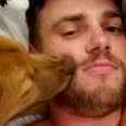 Gus Kenworthy and his dog laying in bed