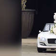 Cat in a white car decorated with a bouquet