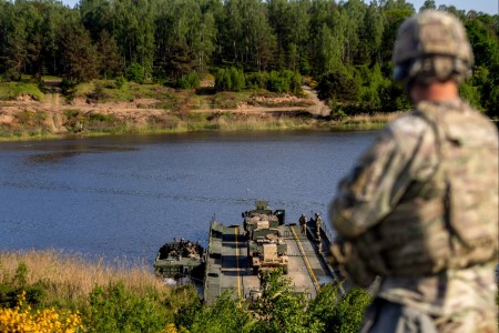 U.S. Army Capt. Joel Self, the commander of the 43rd Multi-Role Bridge Company, 20th Engineer Battalion, watches his company ferry equipment to the far side of a water obstacle at Drawsko Pomorskie Training Center, Poland, May 15, 2024. This wet gap crossing exercise was a pivotal portion of DEFENDER 24 and demonstrated the ability to overcome various terrain in the European region.