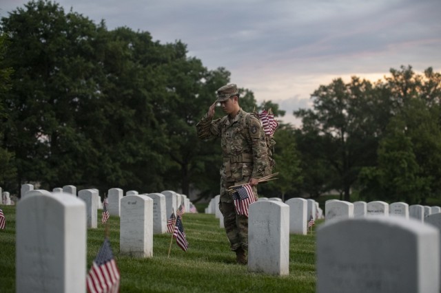 Soldiers from the 3d U.S. Infantry Regiment (The Old Guard) place U.S. flags at gravesites in Arlington National Cemetery, Arlington, Va., May 23, 2024. This was the 76th anniversary of Flags In where over 1,500 service members placed more than 260,000 flags at every gravesite and niche column at Arlington National Cemetery.