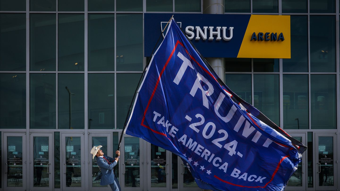 A Donald Trump supporter waved a Trump flag while waiting to be let into the SNHU Arena for a Trump rally on Jan. 19.