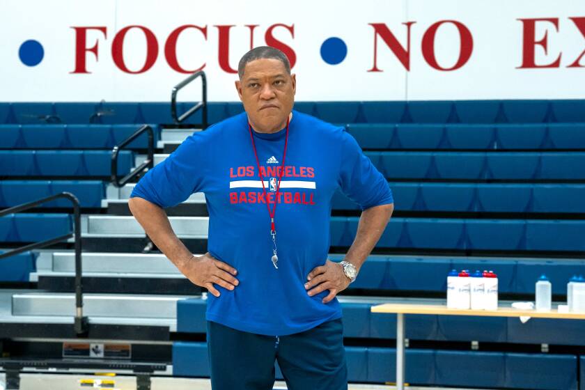 Laurence Fishburne stands on a court with his hands on his hips while portraying then-Clippers coach Doc Rivers 