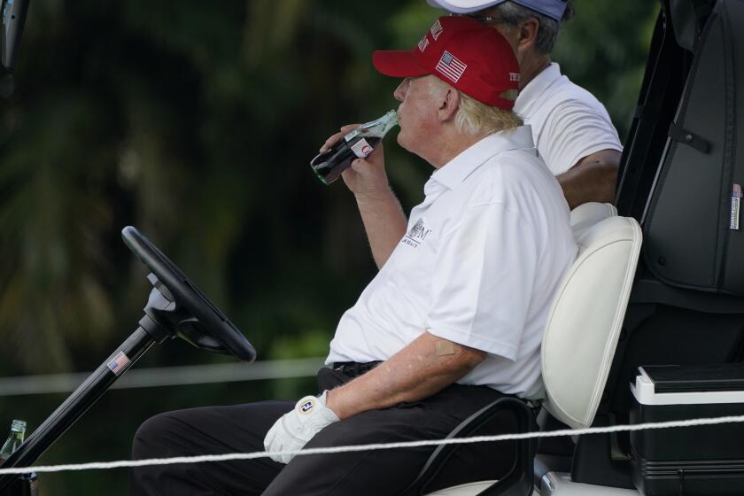 Former President Donald Trump drinks a Diet Coke during the ProAm of the LIV Golf Team Championship at Trump National Doral Golf Club, Thursday, Oct. 27, 2022, in Doral, Fla. (AP Photo/Lynne Sladky)