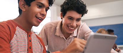 صورة لطالبين ينظران إلى كمبيوتر لوحي.