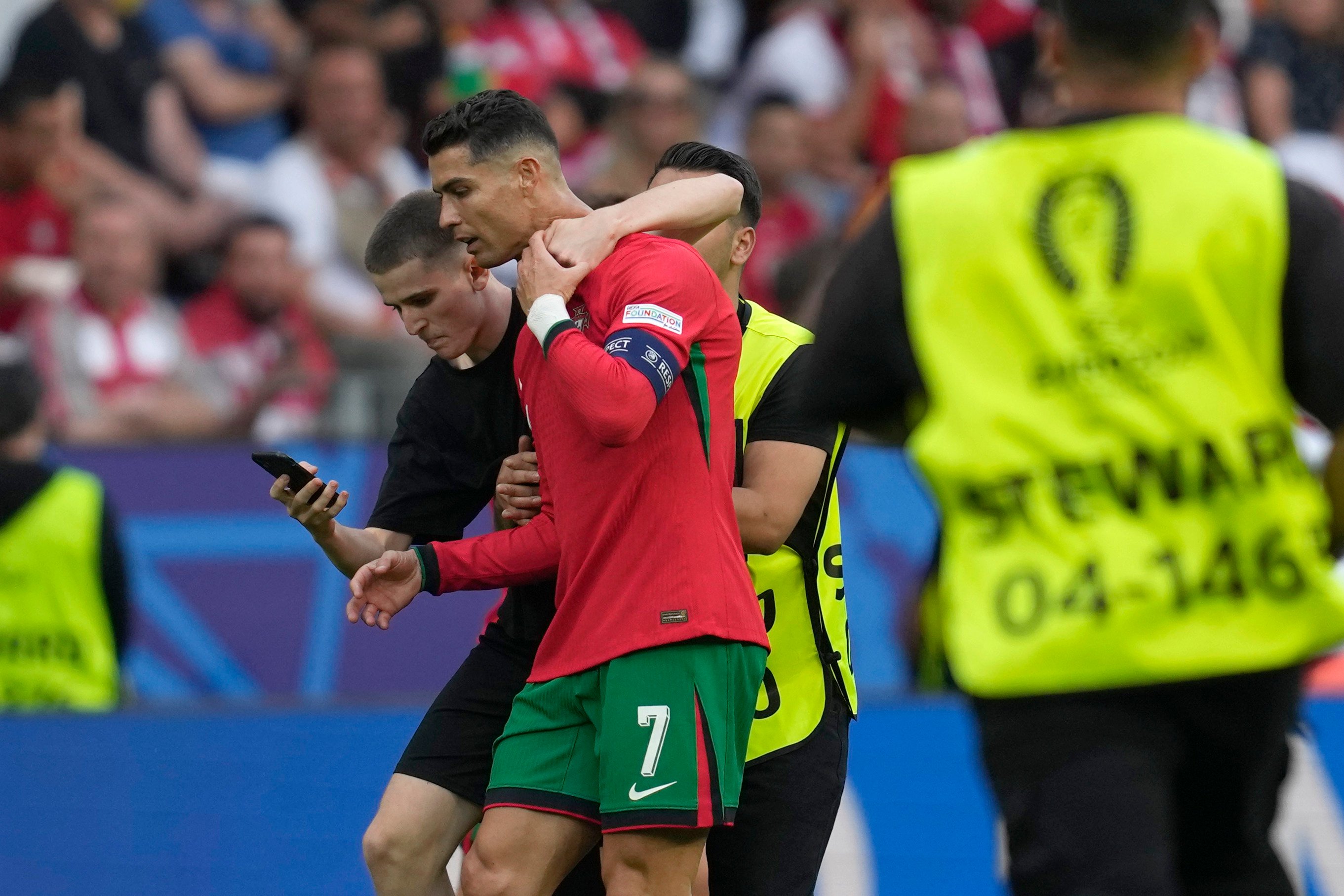 A pitch invader tries to take a selfie with Portugal’s Cristiano Ronaldo during a match between Turkey and Portugal at the Euro 2024 football tournament in Dortmund, Germany on Saturday. Photo: AP