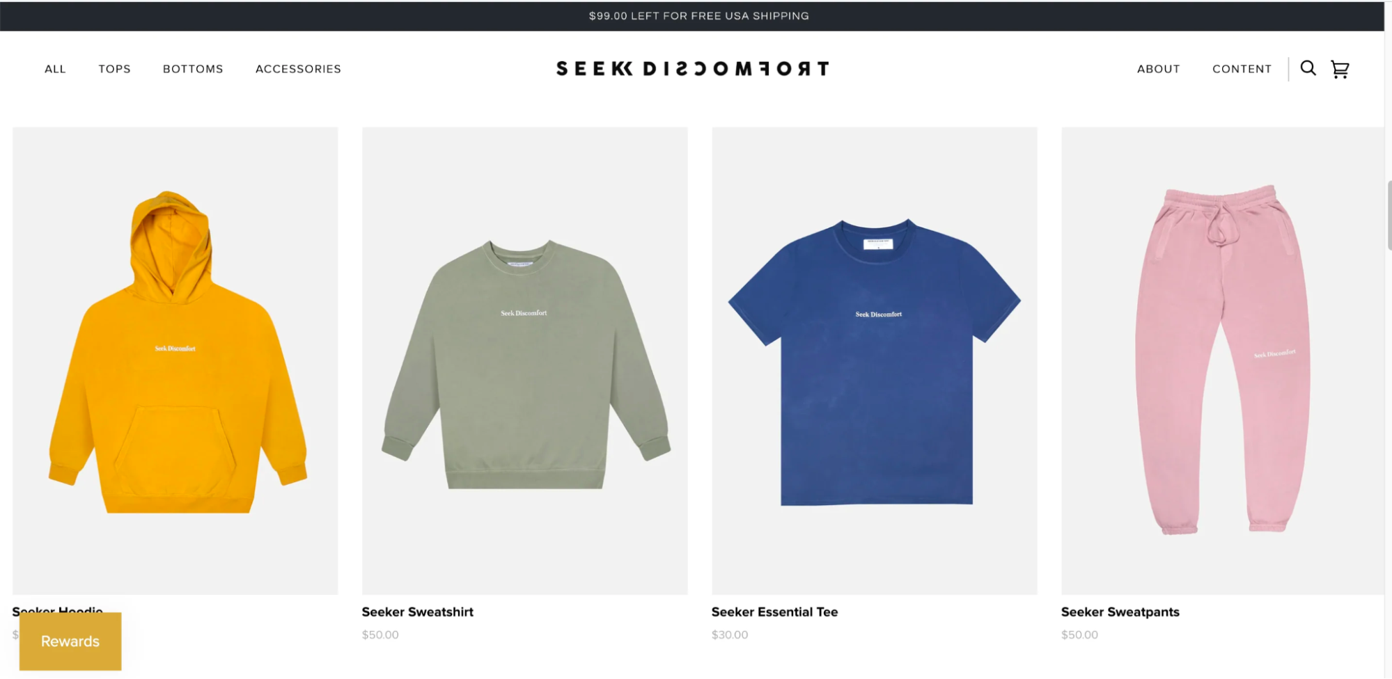 The Seek Discomfort website with brightly colored shirts, sweatshirts, and pants