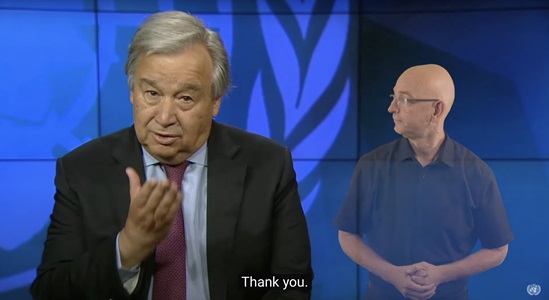 UN Secretary-General talking with sign language interpreter in background
