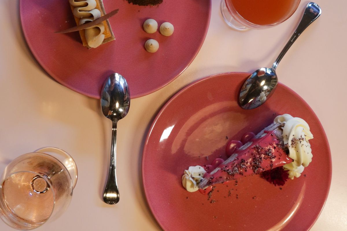 An overhead image of pink plates with slices of cake on them at Tiny Lou’s in Atlanta.