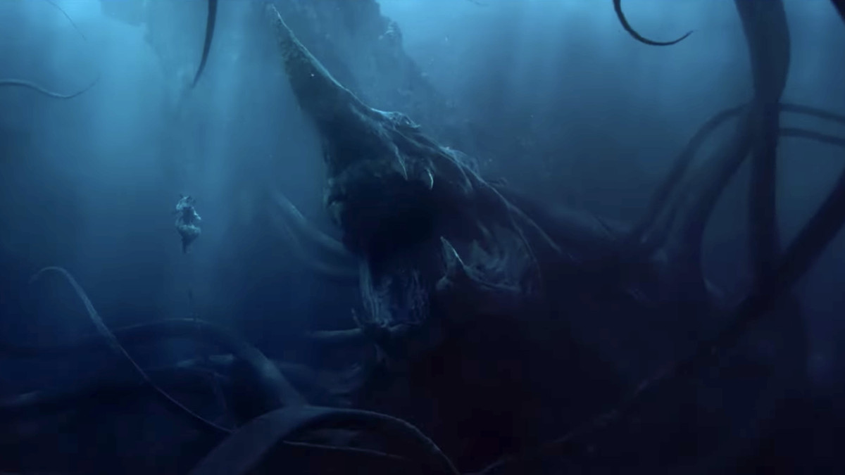A huge sea monster with tentacles, a snaggle-toothed maw, and a prow-like spike on its head floats open-mouthed before a small, floating, humanoid figure in The Lord of the Rings: The Rings of Power S2.