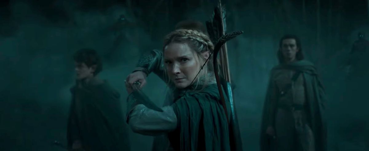 Galadriel (Morfydd Clark) hoding a sword with people behind her