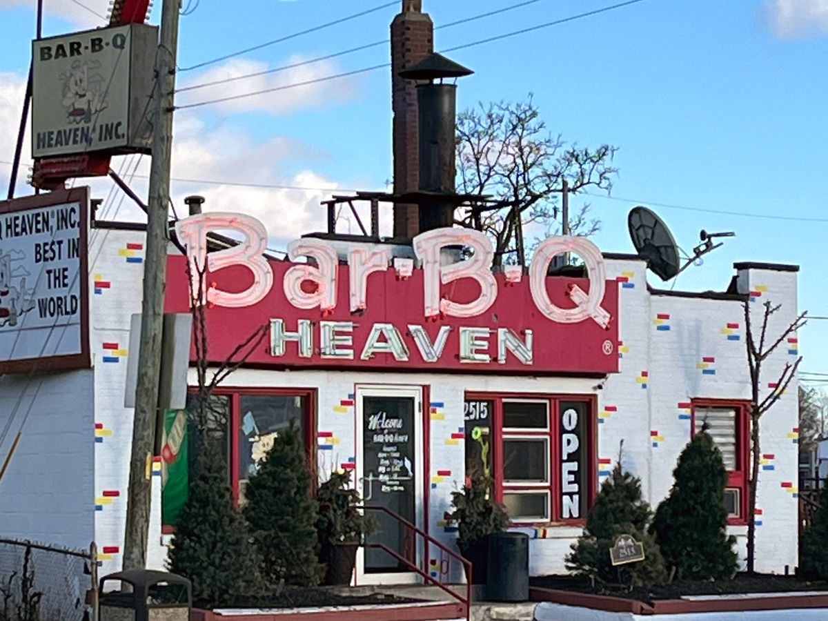A restaurant exterior with a large sign reading Bar-B-Q Heaven.