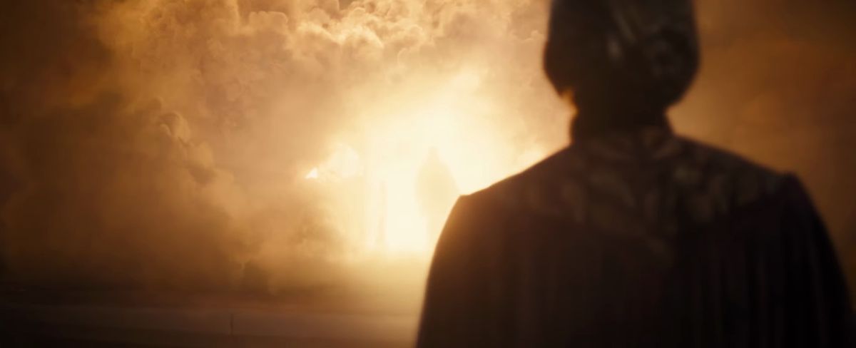 Celebrimbor stands in front a huge, bright, smoky fire, with a figure standing in its glowing center in the trailer for season 2 of The Lord of the Rings: The Rings of Power
