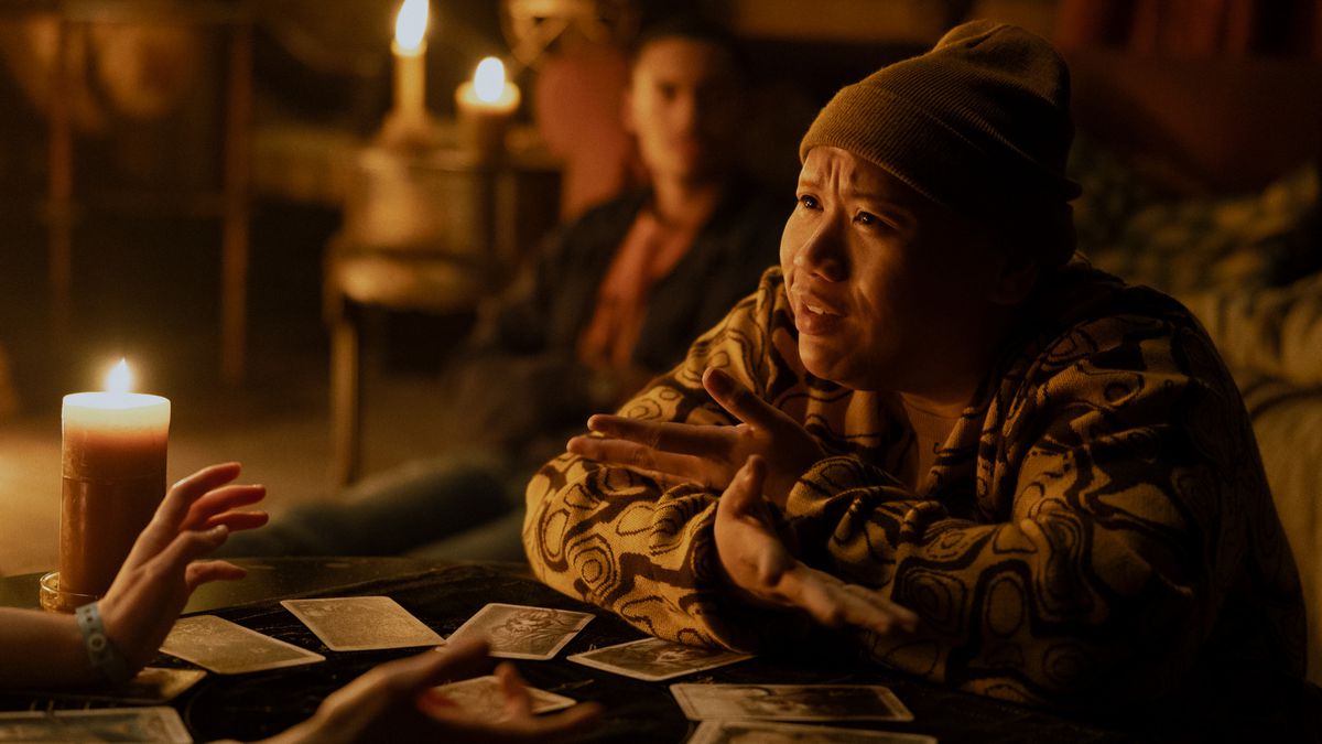 Jacob Batalon gestures with his hands as he’s being dealt a tarot deck in the movie Tarot.