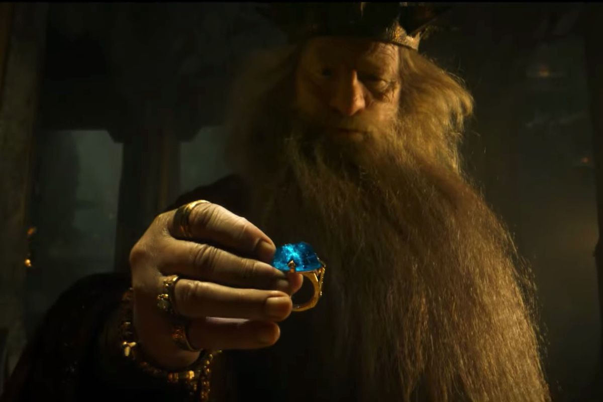 King Durin picks up a golden ring with a huge blue gem set into it in The Lord of the Rings: The Rings of Power.