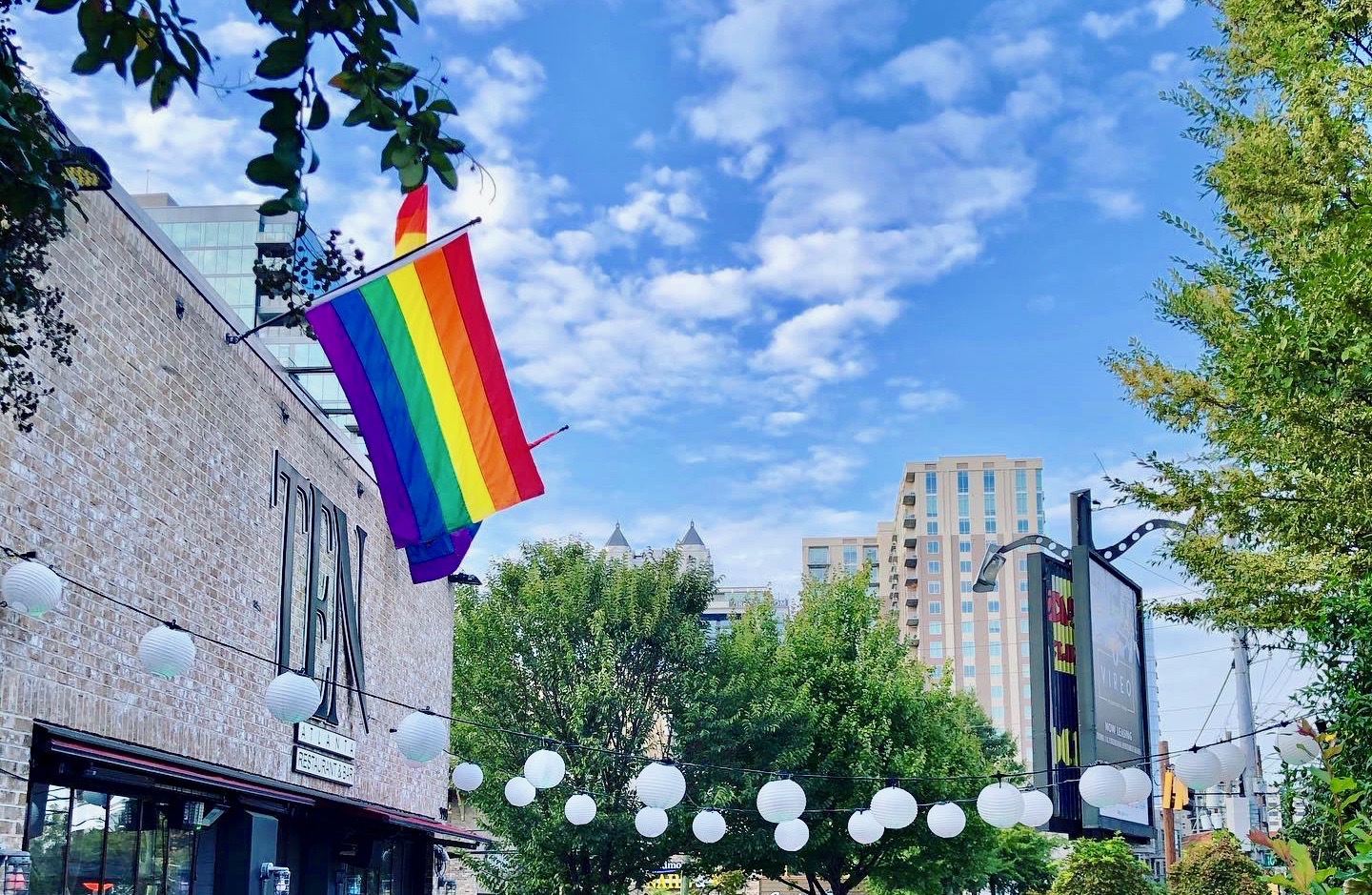 The patio and outside entrance of X (TEN) in Midtown with two rainbow pride flags