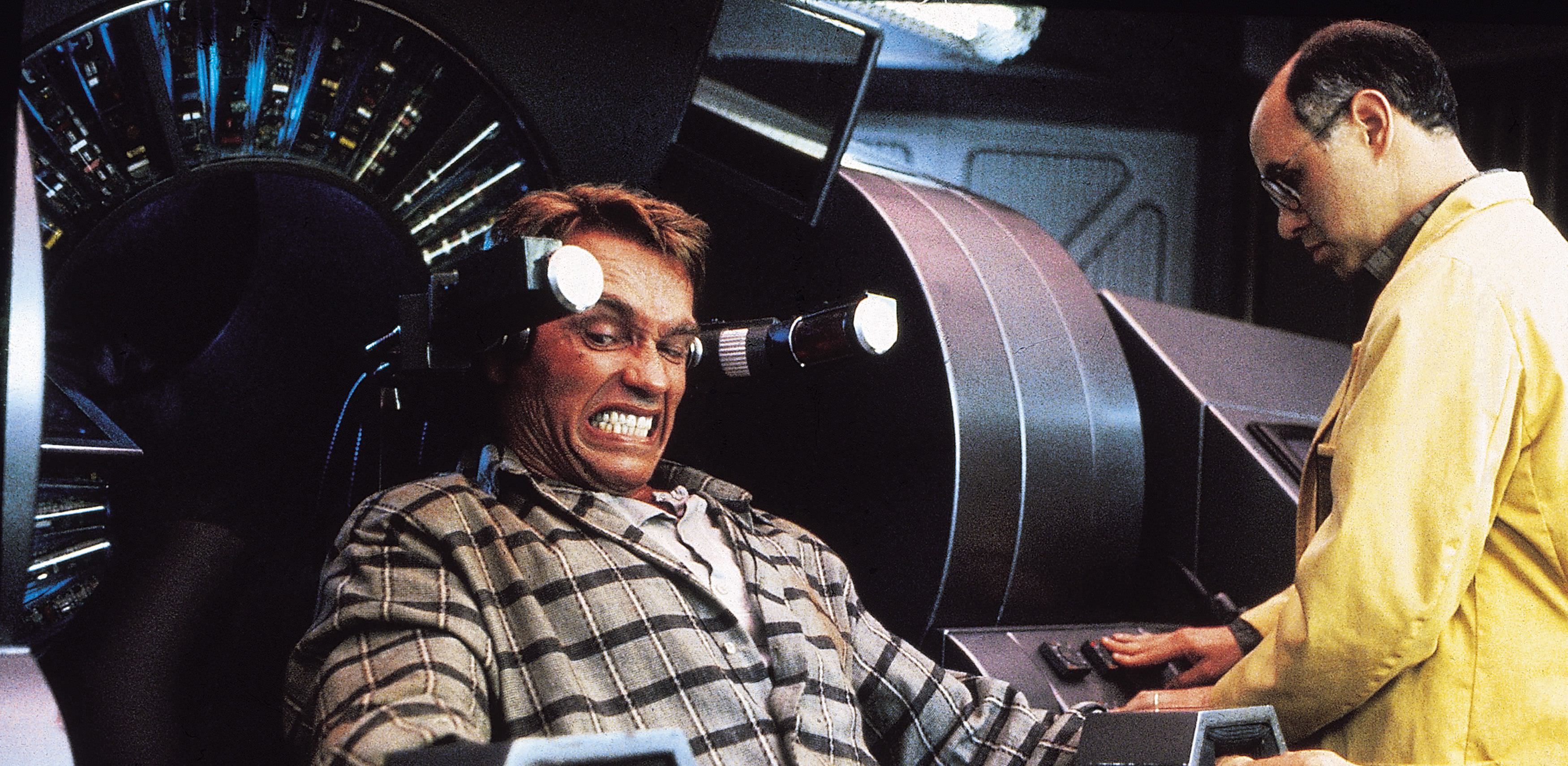 Arnold Schwarzenegger grimaces as memories are implanted in his head — or not?!? — in Total Recall.