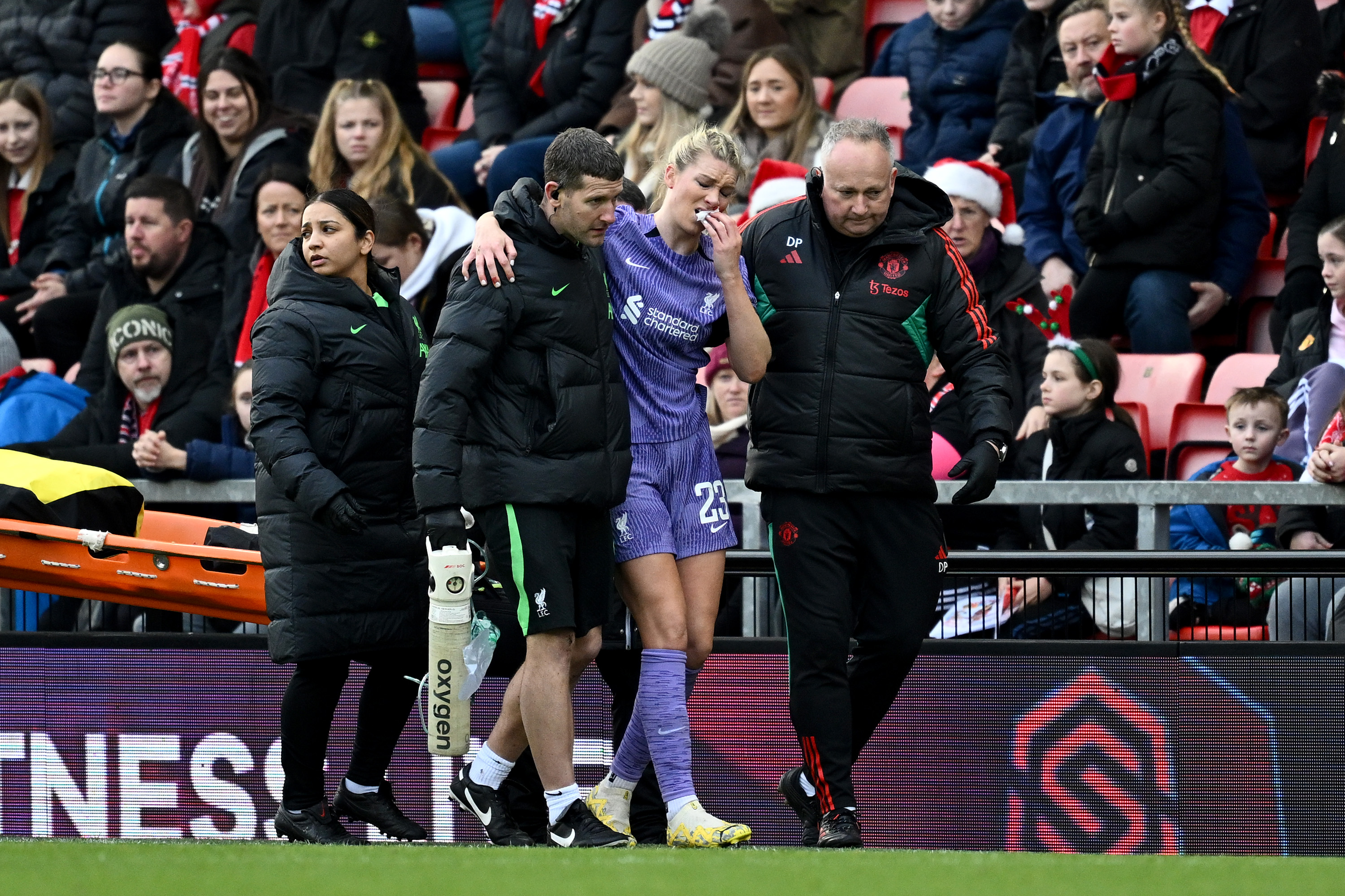 Gemma Bonner helped off the pitch after picking up a head injury against Manchester United