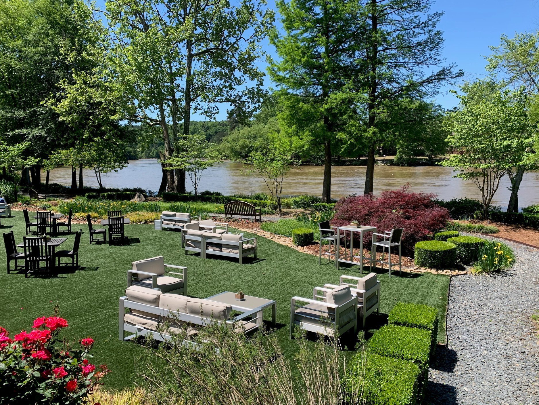The outdoor green space at Ray’s on the River in Atlanta, with a view of the river in the background.