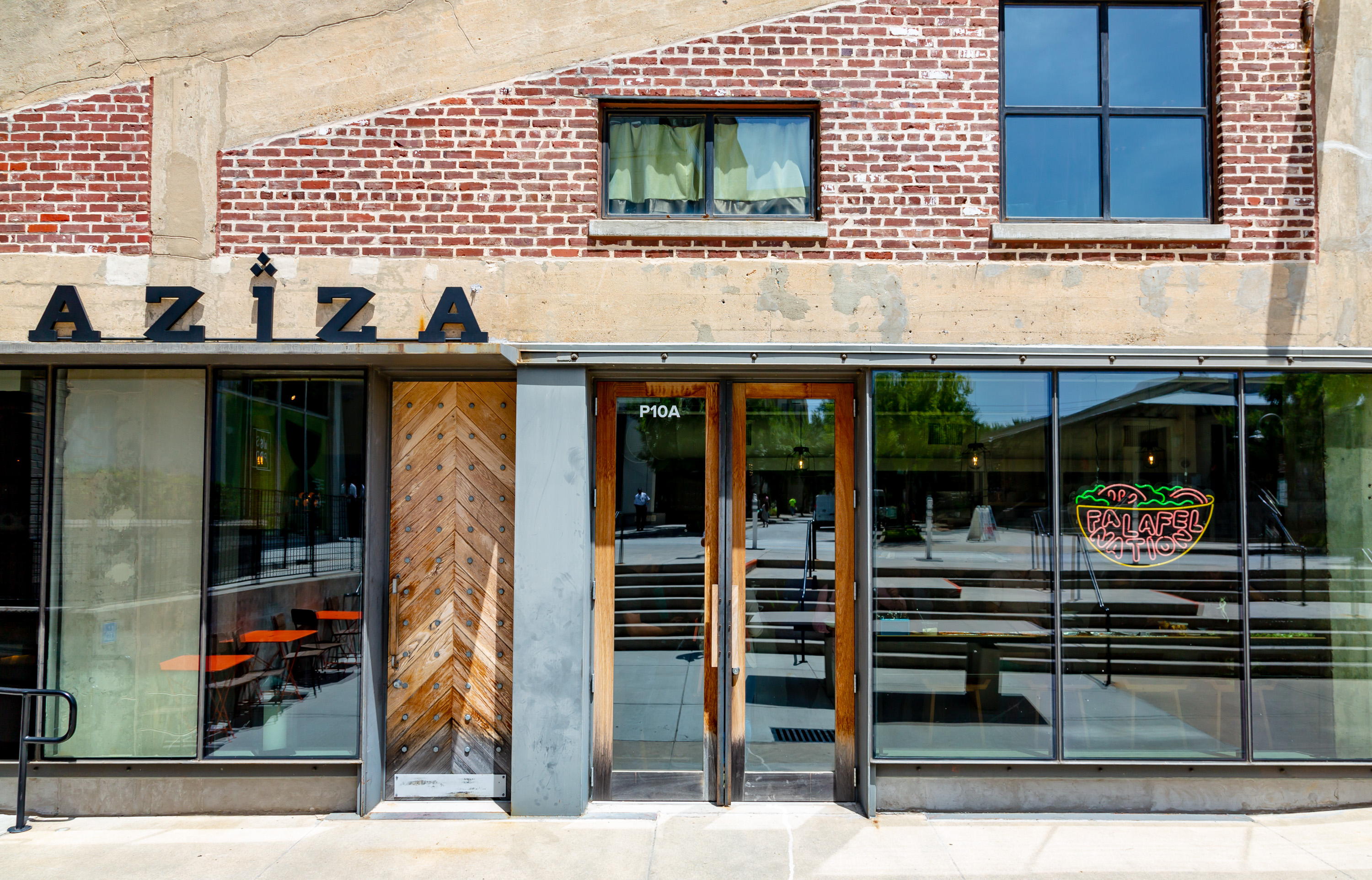 The front doors and signs for restaurants Aziza and Falafel Nation at Westside Provisions District.