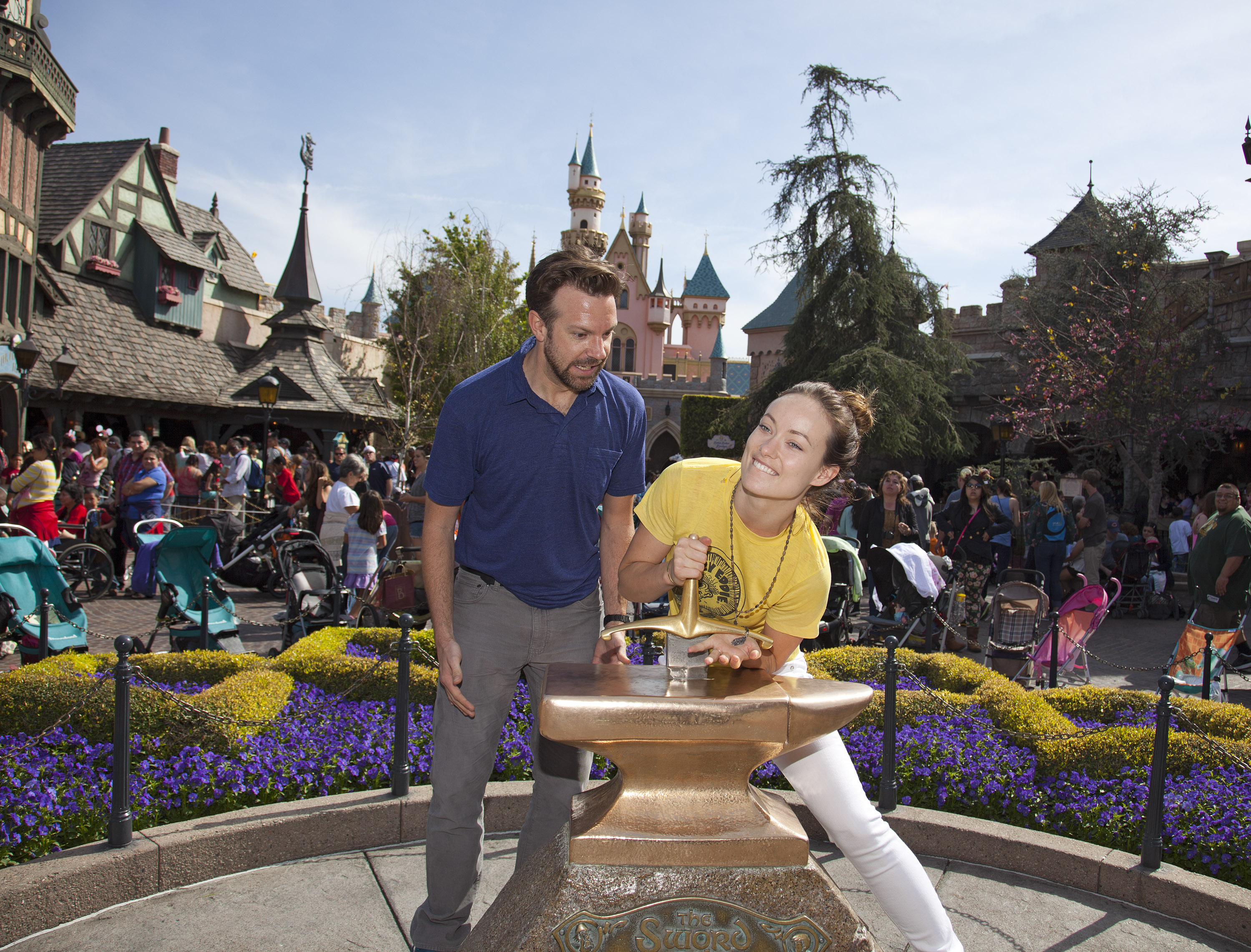In this handout photo provided by Disney Parks, Newly-engaged couple Jason Sudeikis and Olivia Wilde try their luck at removing the “Sword in the Stone” at Disneyland park in Anaheim on March 26, 2013 in Anaheim, California. (GETTY)
