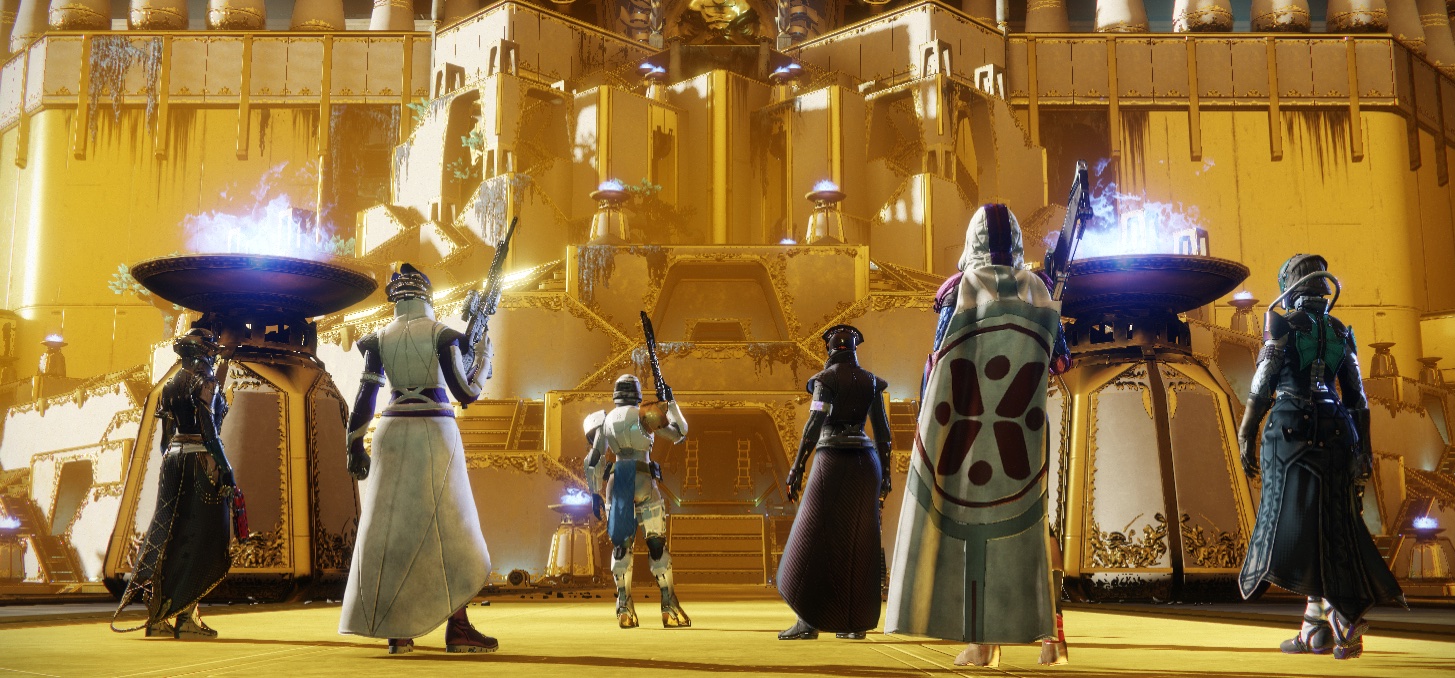 Six player characters in Destiny 2 standing with their backs to the camera, gazing up at a massive gold temple. This is the location for the Leviathan raid in the game, a group activity