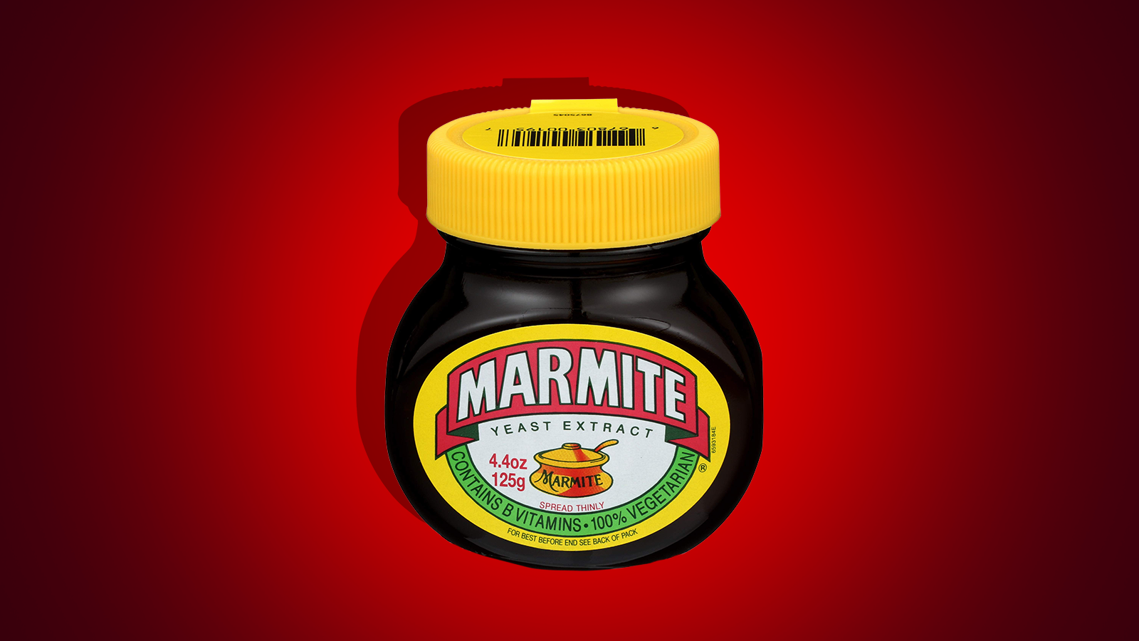 A jar of Marmite against a red backdrop.