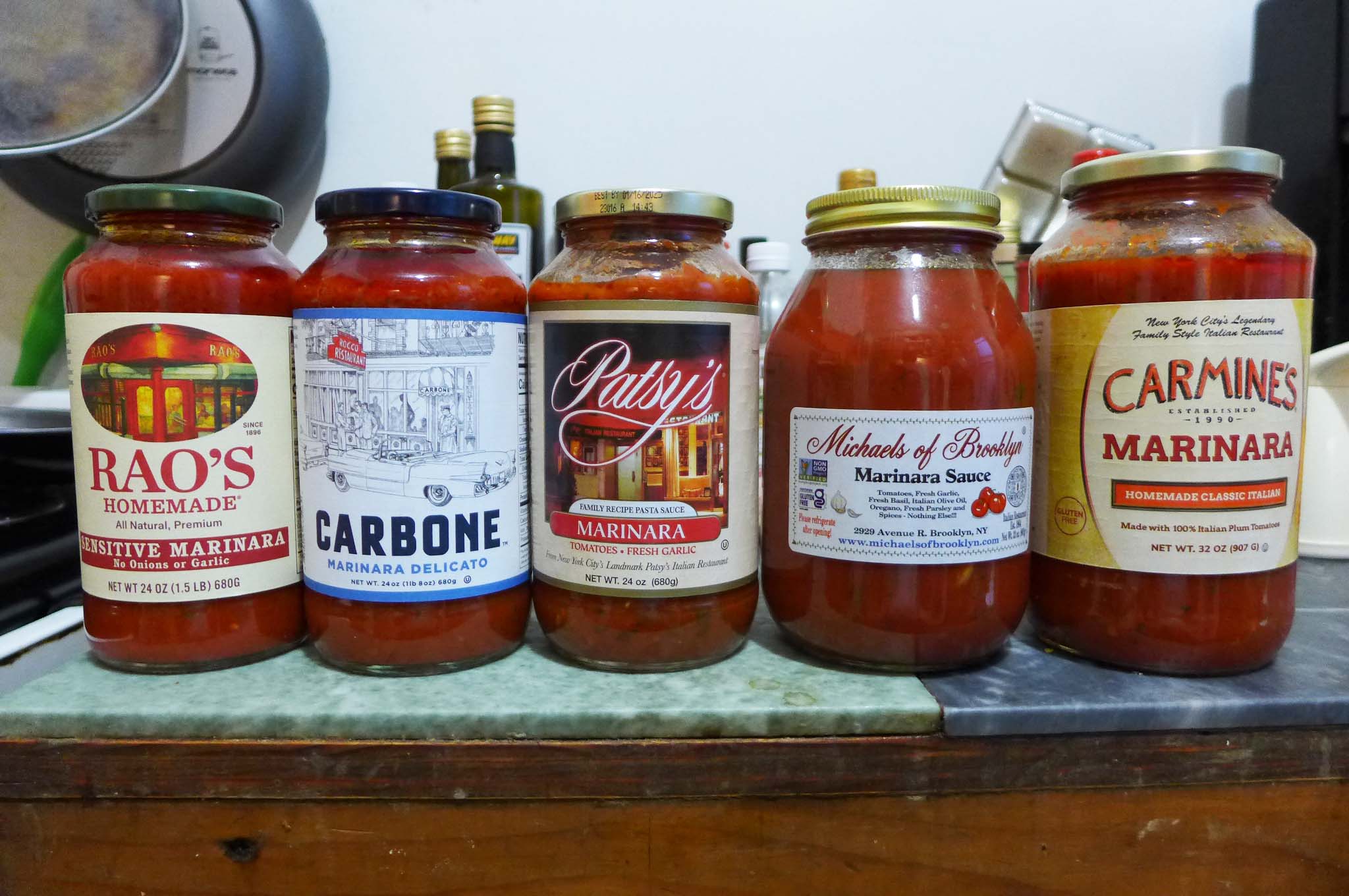 five jars of tomato sauce on a counter