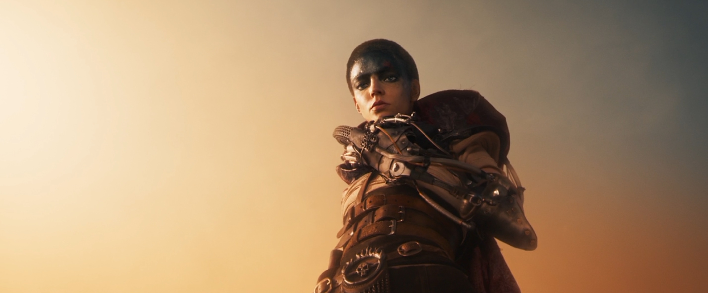 Furiosa (Anya Taylor-Joy) stands above the camera, glowering down into the lens, in George Miller’s Furiosa