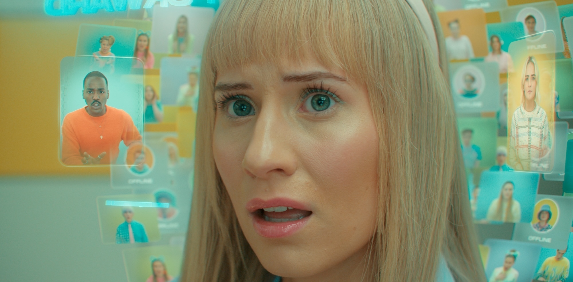 A close up of Lindy, her face visible behind a bunch of transparent screens projected around her face in the Doctor Who episode “Dot and Bubble.”