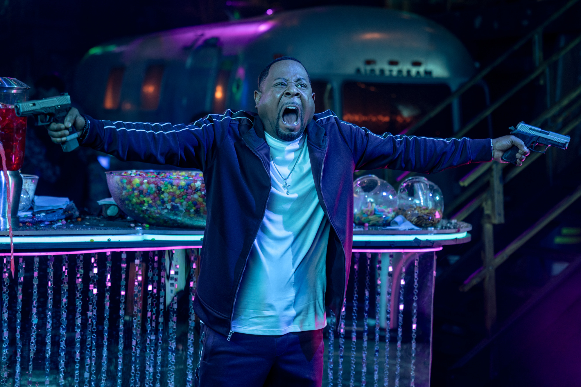 Martin Lawrence as Marcus Burnett yelling as he wields two guns in the club in Bad Boys: Ride or Die