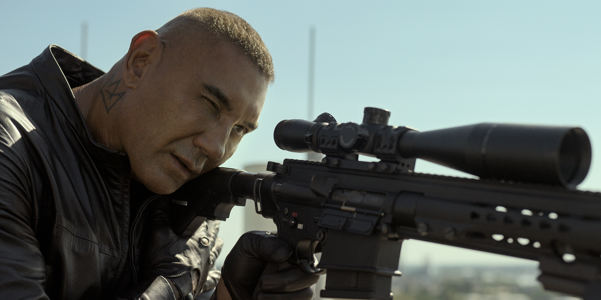 Dave Bautista peers down a sniper rifle in The Killer’s Game