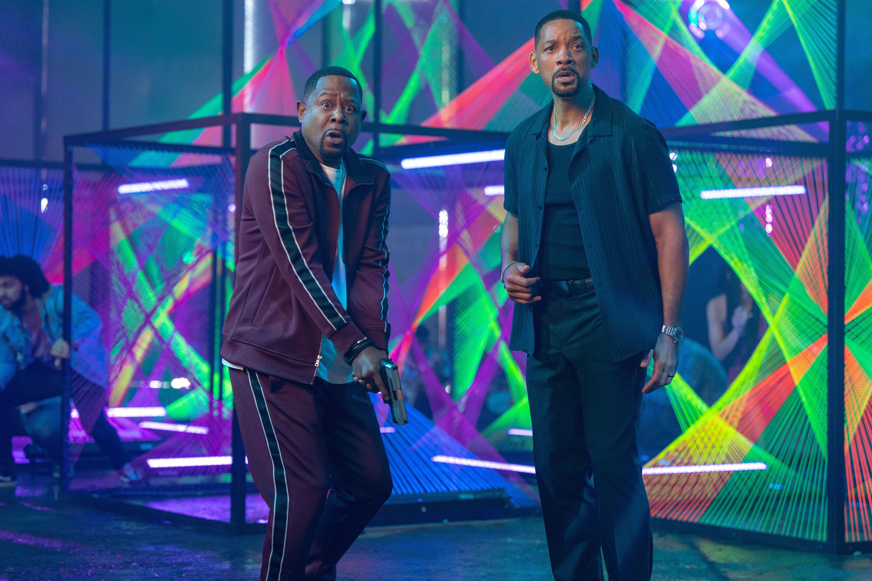 Martin Lawrence and Will Smith stand in a neon-bathed room, making surprised faces, in Bad Boys: Ride or Die