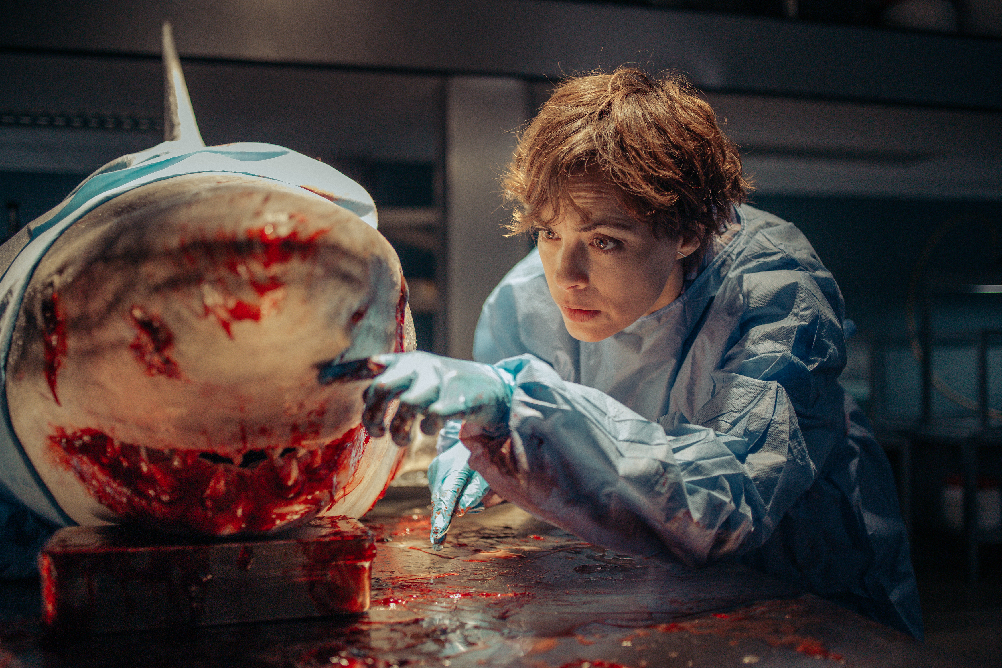 Ocean researcher Sophia (Bérénice Bejo) leans in for a close look at the bloody snout of a large shark she’s dissecting in a lab in Xavier Gens’ Netflix shark thriller Under Paris