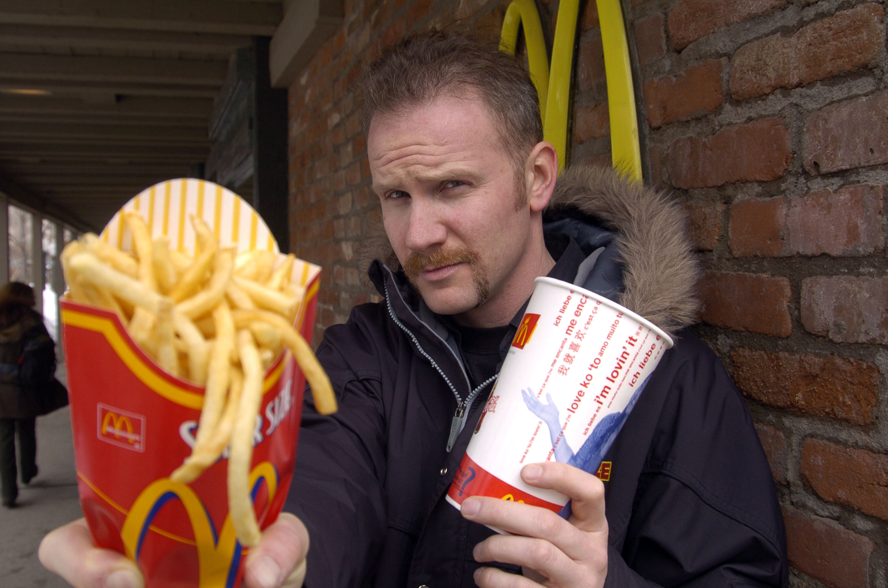 A man in a mustache holds McDonald’s food