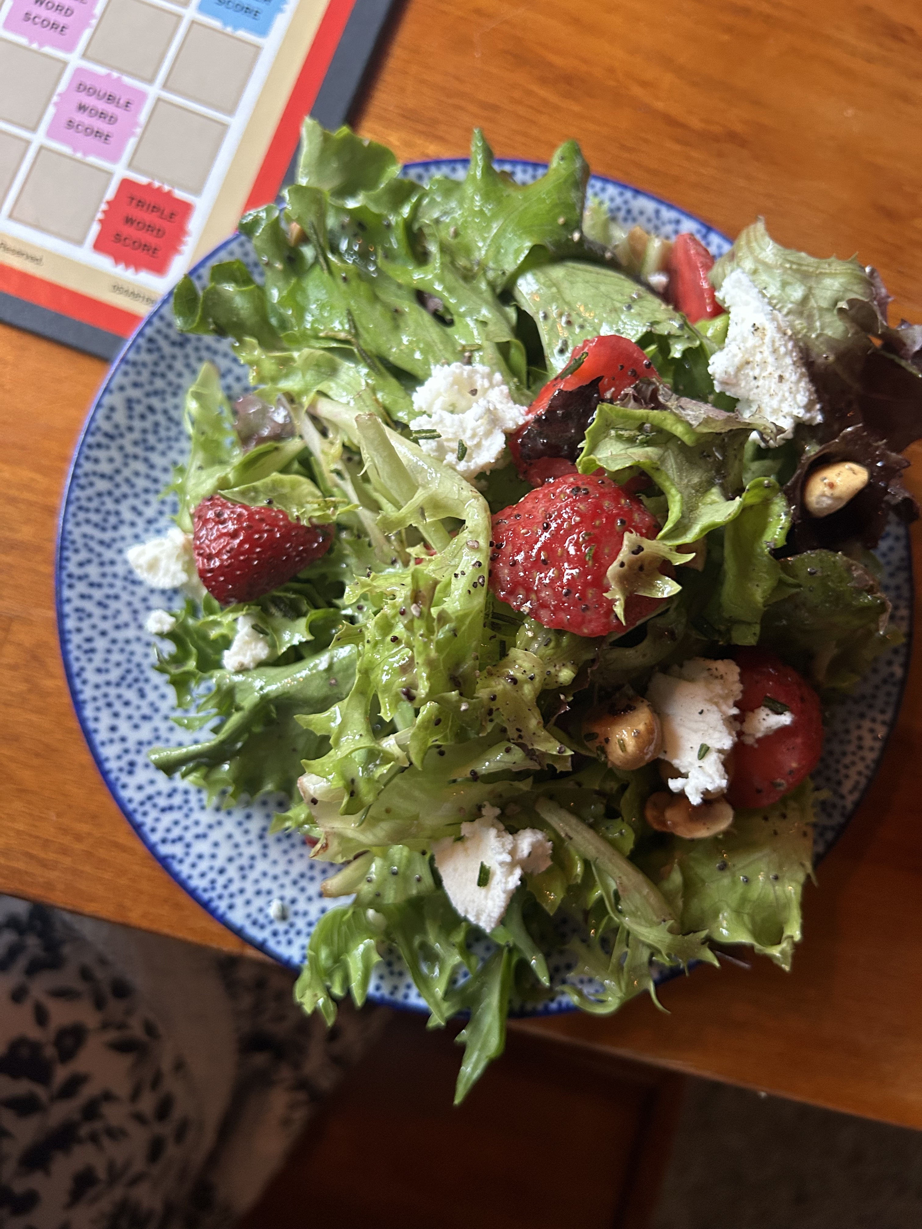 A salad with strawberries, ricotta, and hazelnuts.