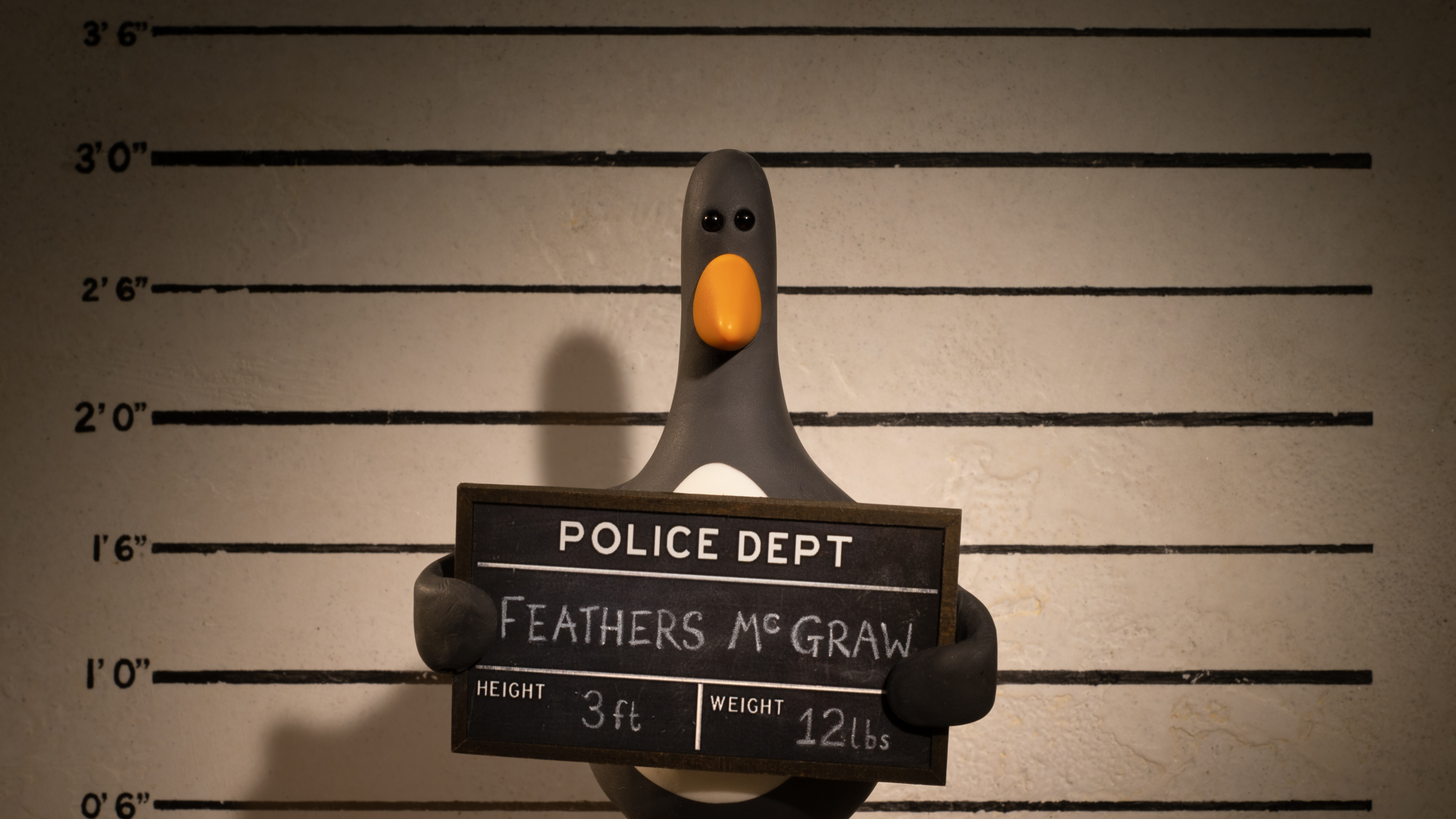 Wallace and Gromit’s nemesis Feathers McGraw holds up his police sign for his mug shot in Vengeance Most Fowl