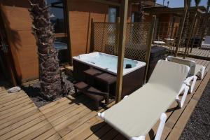 a hot tub sitting on a deck with two chairs at Magic Natura Resort in Benidorm