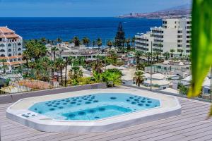una piscina en una terraza con vistas al océano en Spring Hotel Bitácora, en Playa de las Américas