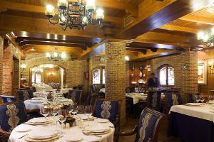 restauracja z białymi stołami i krzesłami oraz żyrandolem w obiekcie AC Hotel Almería by Marriott w mieście Almería