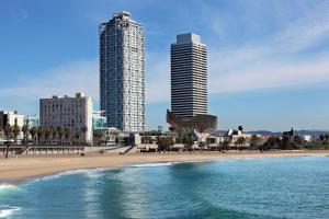فندق آرتس برشلونة في برشلونة: مبنيان طويلان على شاطئ بجوار المحيط