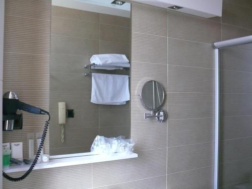 baño con ducha con espejo y teléfono en Hotel Los Angeles, en Guarnizo