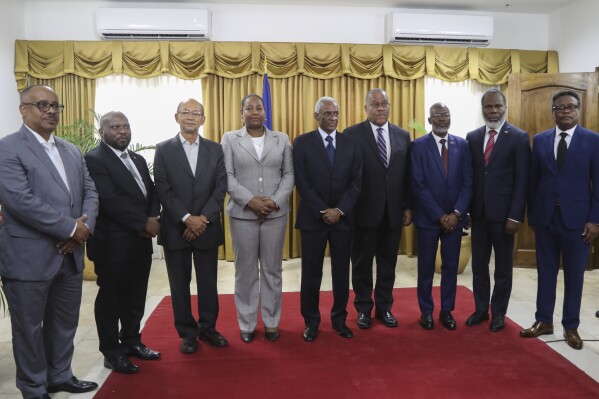 Garry Conille, fourth from right, poses for photos with members of the transitional council after his swearing-in ceremony as prime minister in Port-au-Prince, Haiti, Monday, June 3, 2024. (AP Photo/Odelyn Joseph)