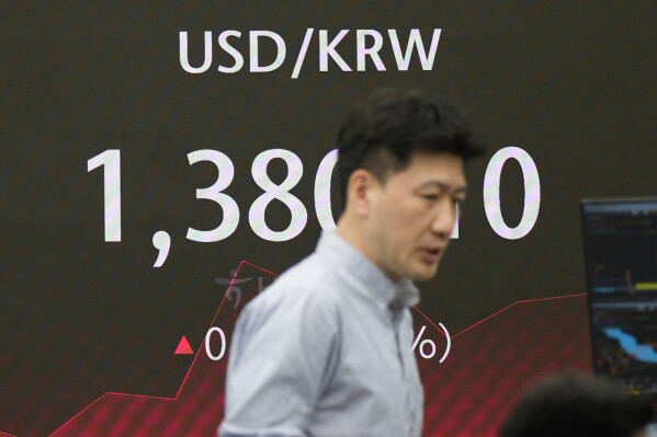 A currency trader walks by the screen showing the foreign exchange rate between U.S. dollar and South Korean won at a foreign exchange dealing room in Seoul, South Korea, Friday, May 31, 2024. (AP Photo/Lee Jin-man)