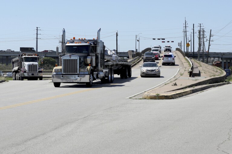Galveston police officers talk to drivers attempting to get to Pelican Island in Galveston, Texas, on Wednesday, May 15, 2024. The bridge, the only road access to and from the island, was closed after a barge crashed into it. (Jennifer Reynolds/The Galveston County Daily News via AP)