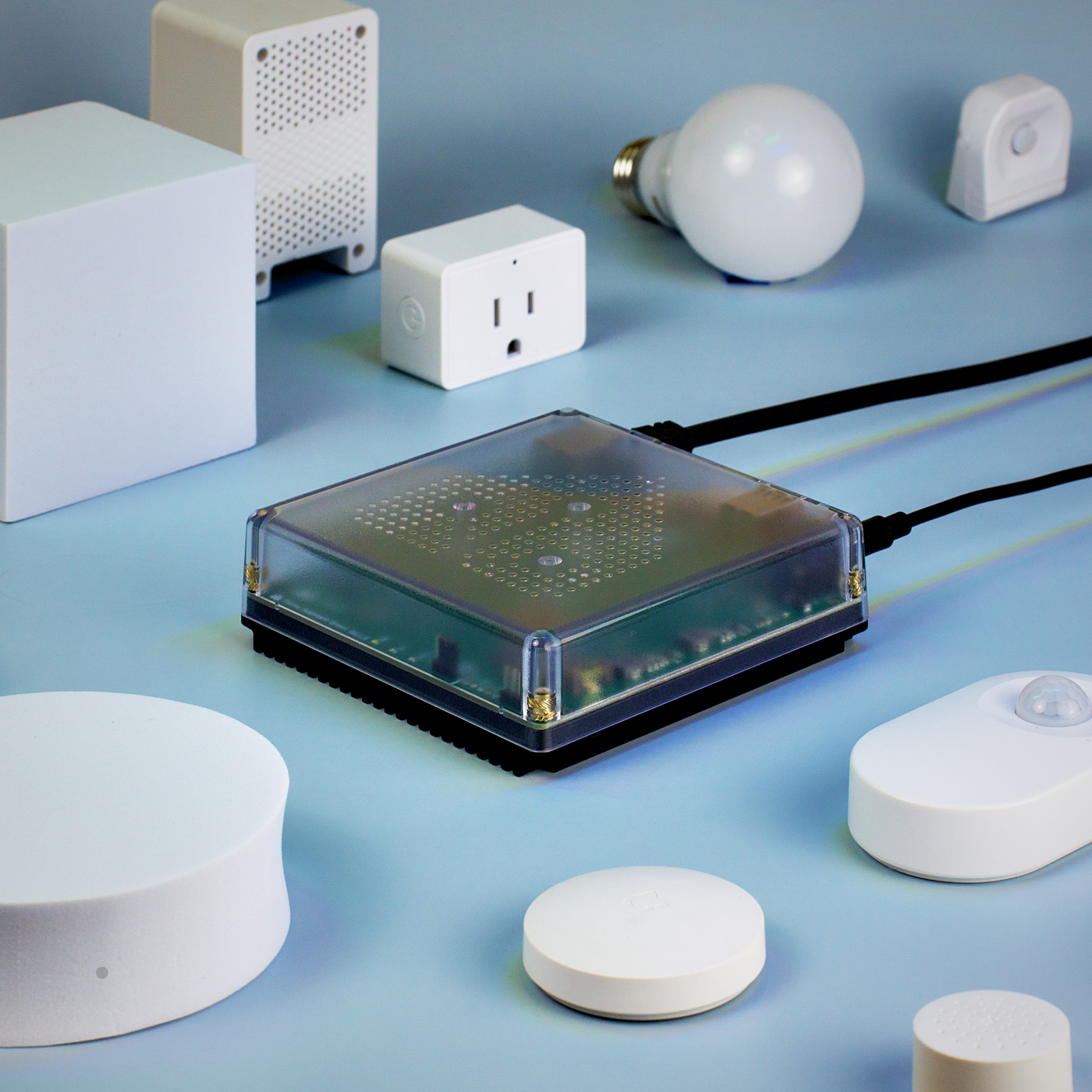 A Home Assistant Green box surrounded by smart plugs, lights, sensors, and other gadgets.