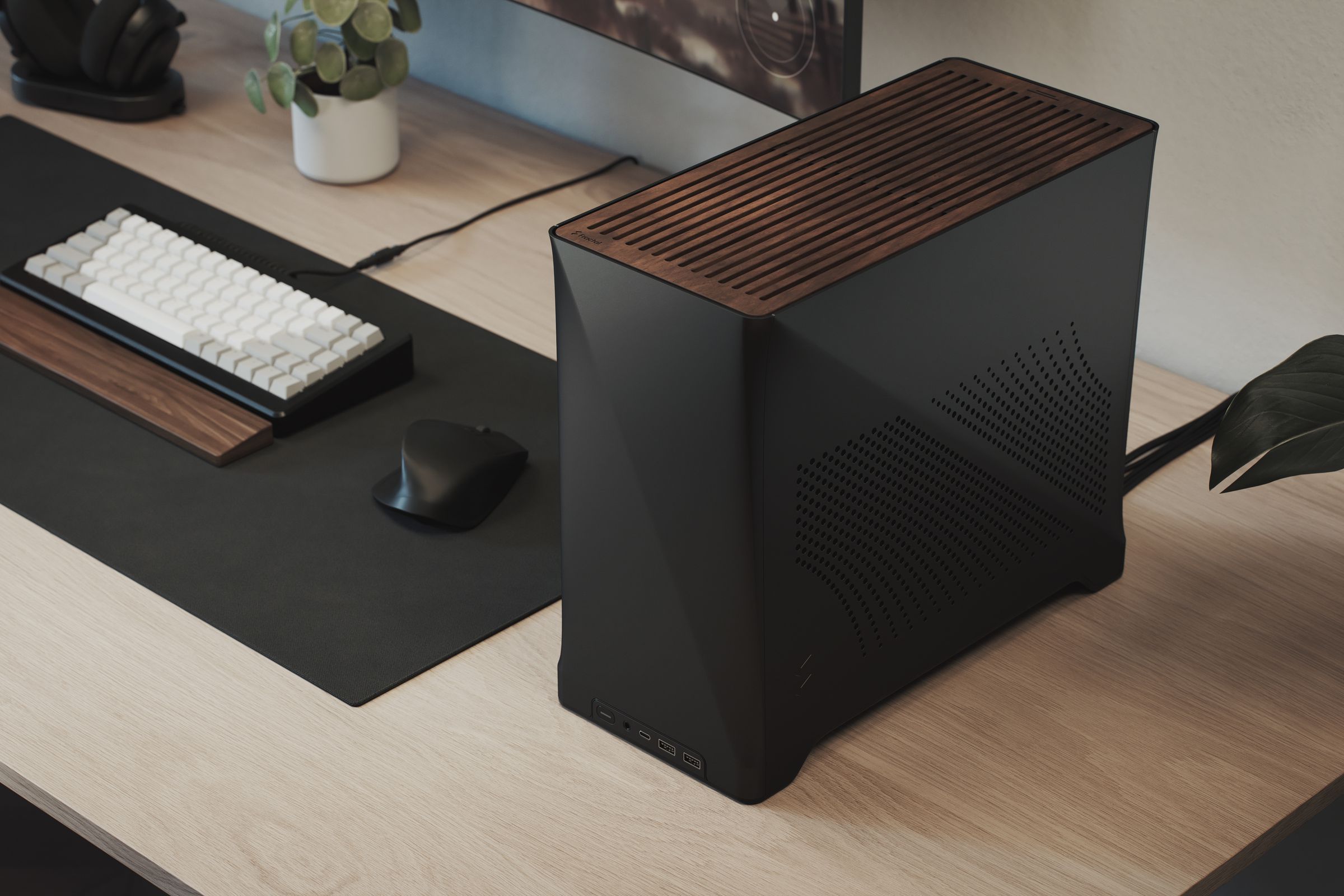 A small desktop PC case with wood paneling on the top next to a keyboard, mouse, and monitor.