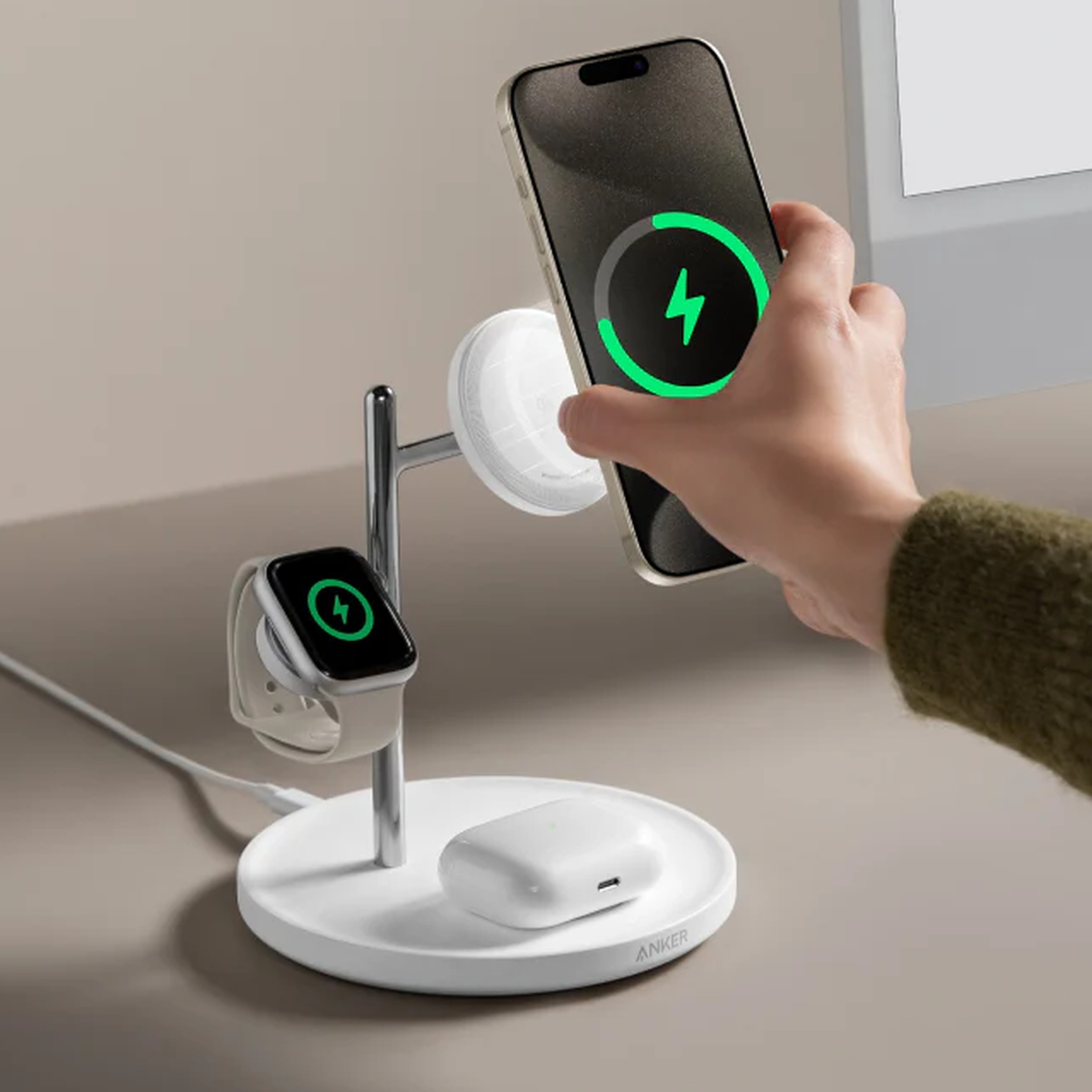 Someone placing an iPhone onto an Anker charging stand