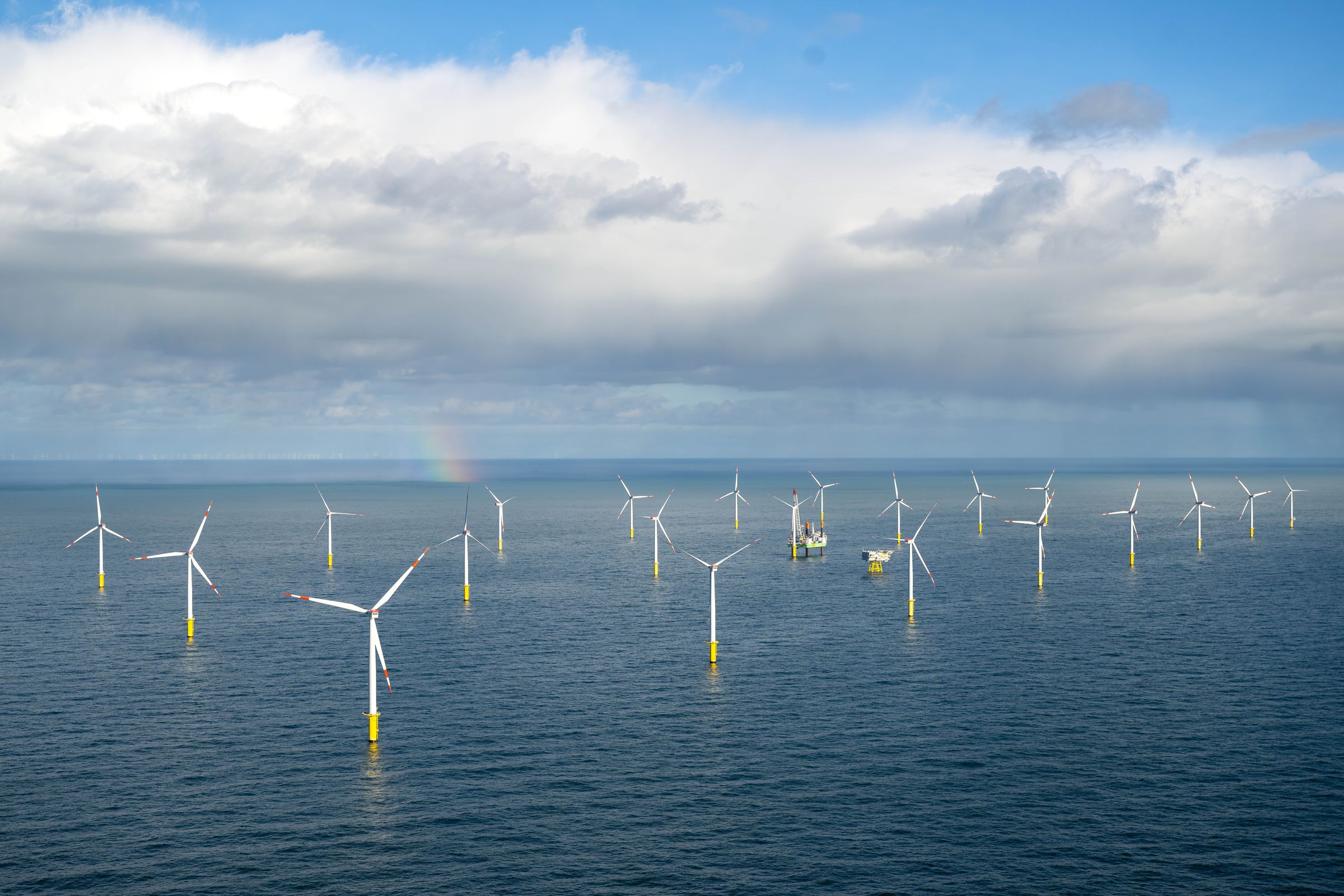 Several rows of wind turbines standing in the sea.
