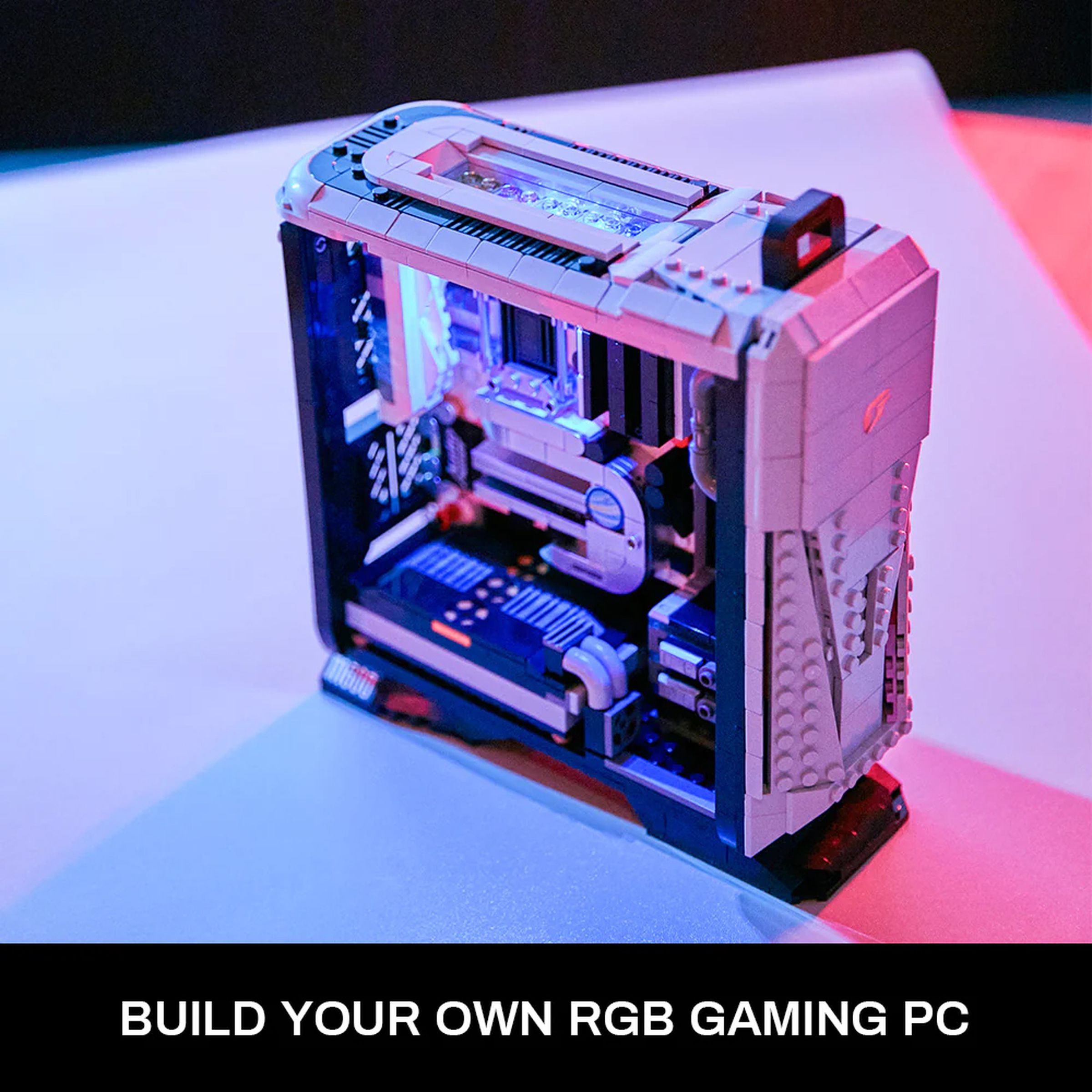 Press photo of a miniature gaming desktop model made out of Lego-like bricks. The model is mostly gray-colored with typical gamery accents, including RGB lighting and little brick models of a motherboard, graphics card, PSU, and storage drives.