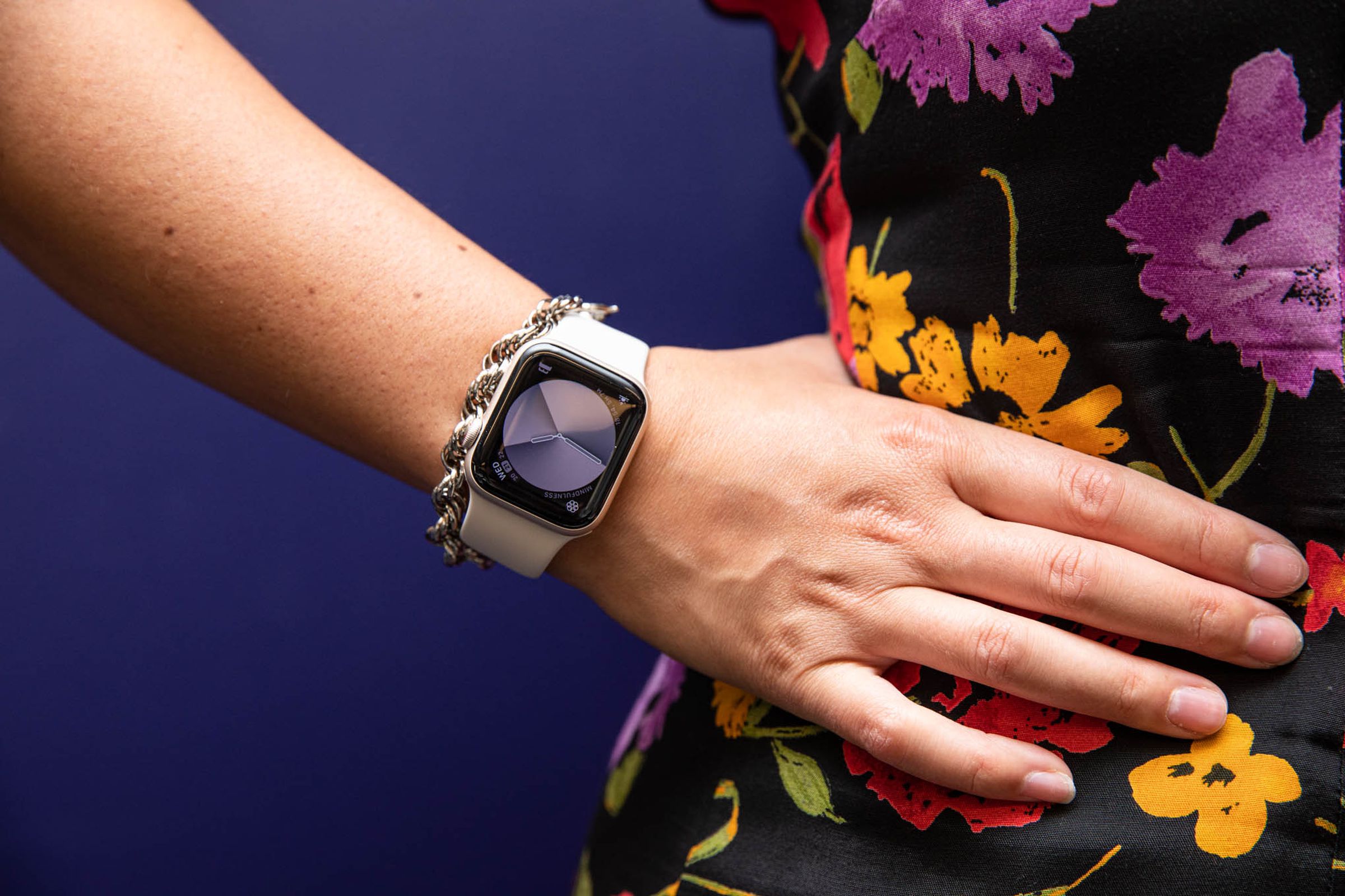 Woman in floral dress with hand on hip modeling Apple watch SE (2022)